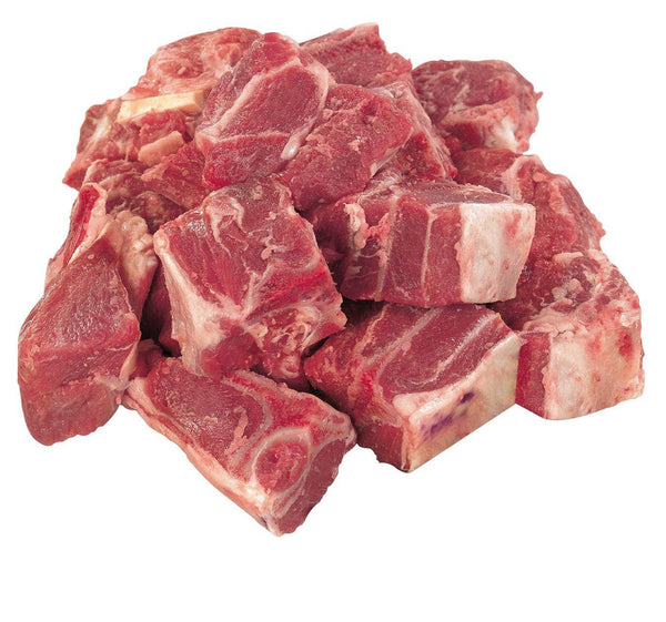Pile of raw beef stew meat chunks with fat, isolated on white background