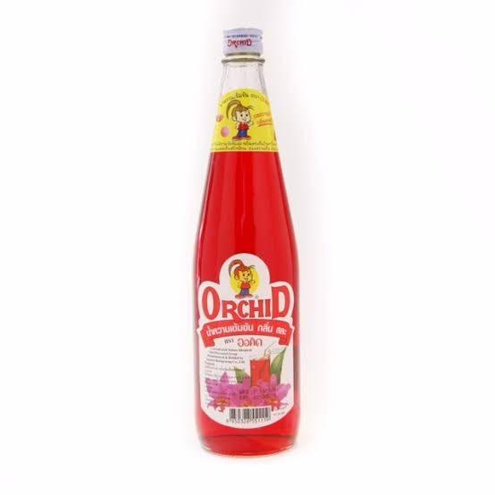 Glass bottle of Orchid brand red syrup with floral design and cartoon mascot on label