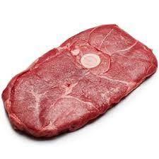 Raw sliced beef meat with marbling and a small white label on a white background