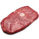 Raw sliced beef meat with marbling and a small white label on a white background