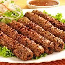 Grilled kebabs served on lettuce with fresh green onions and dipping sauce