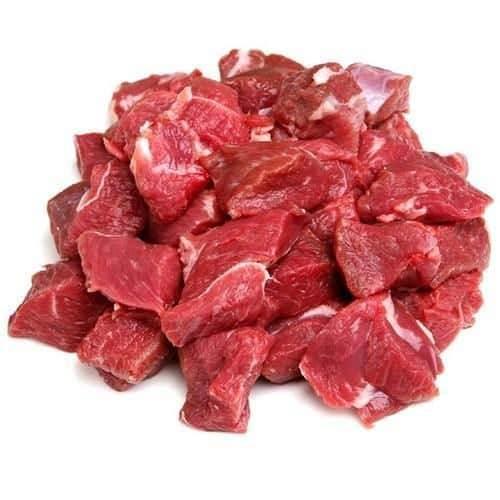 Fresh raw diced mutton pieces with marbled fat on white background