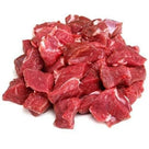 Fresh raw diced mutton pieces with marbled fat on white background