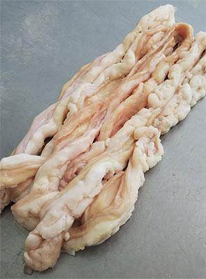 Raw pork intestine laid out on a flat gray surface, showing folds and natural fat texture
