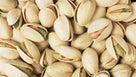 Close-up of shelled pistachio nuts with beige shells and green kernels
